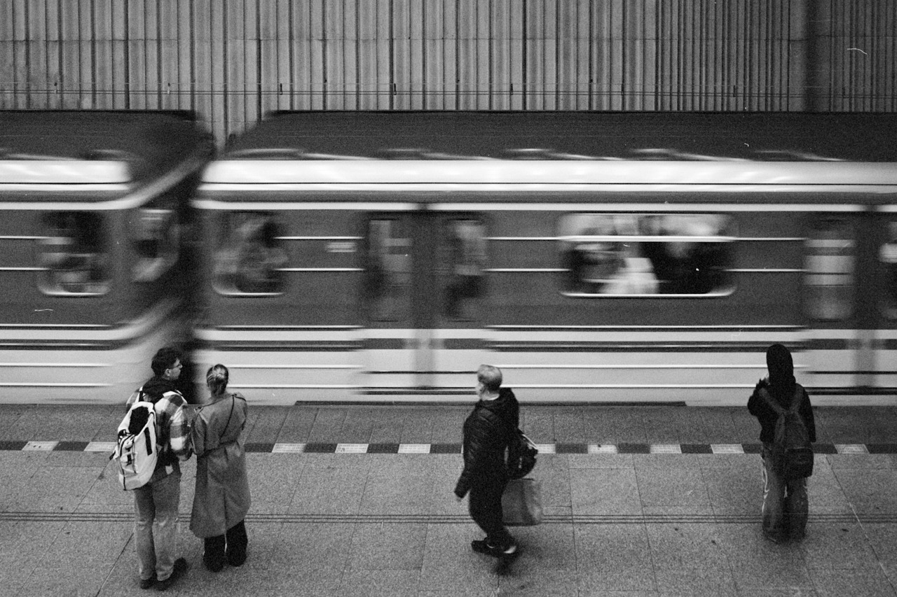 People standing on an underground platform while a train passes in a blur.